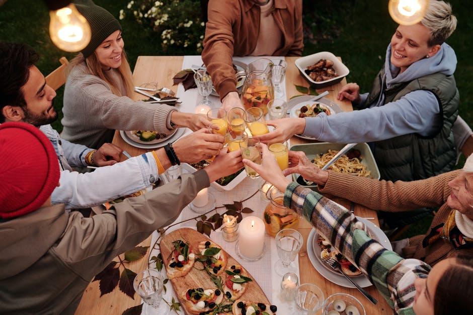 people toasting at table with food